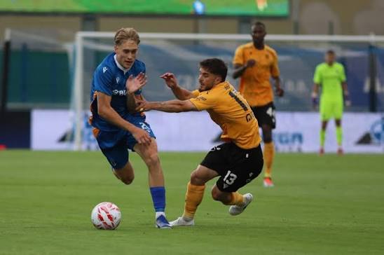 Club player shielding the ball from an opponent during a league match