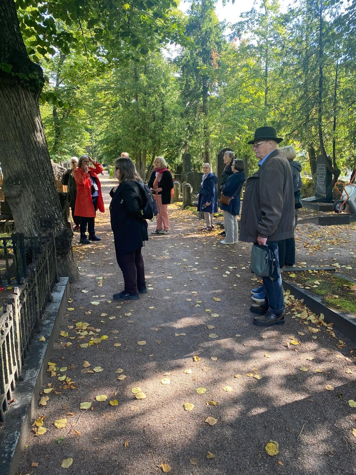Members on a guided remembrance walk among autumn trees